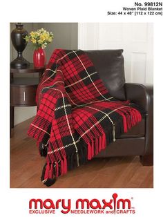 a red and black plaid blanket sitting on top of a leather chair in a living room