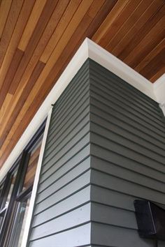 the side of a house with wood paneling on the ceiling and windows in it