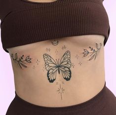 a woman's stomach with a butterfly tattoo on her lower body and leaves around the waist