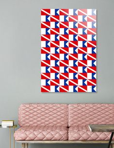 a red, white and blue abstract painting on a gray wall above a pink couch