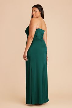 a woman in a green dress with her back to the camera