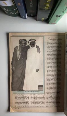 an old newspaper with two men standing next to each other in front of some books