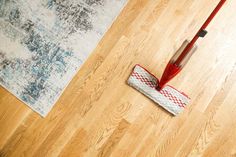 a red mop is on the floor next to a rug