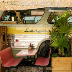 an old bus converted into a restaurant with tables and chairs