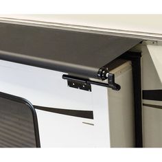 an rv door is open to show the side window and awnings that are closed