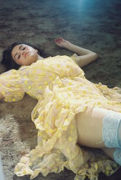 a woman laying on the ground in a dress