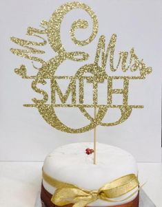 there is a cake with a gold bow on the top and it has a name that says, miss smith