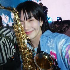 a woman holding a saxophone in front of her face