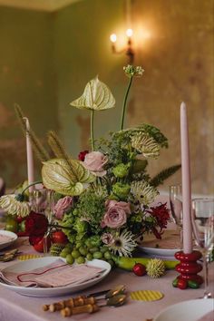 the table is set with flowers, candles and other things to decorate it for dinner