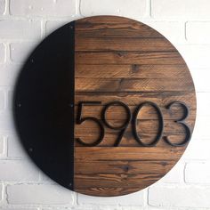 a round wooden plaque with the number 350 on it, mounted to a brick wall