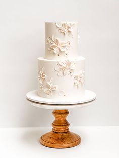 a three tiered cake with white flowers on it