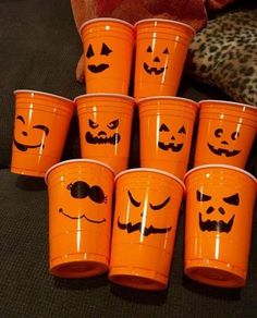 orange plastic cups with faces drawn on them