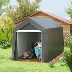 an outdoor storage shed with two lawn mowers in the front and side doors open