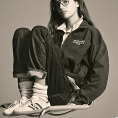 a young woman sitting on top of a skateboard