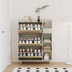 a shelf with shoes and baskets on it in a white room next to a potted plant