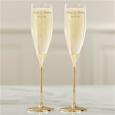 two champagne flutes sitting on top of a table