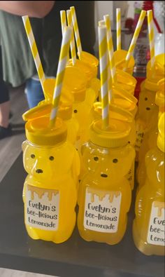 there are many yellow plastic bottles with straws in them that have bears on them