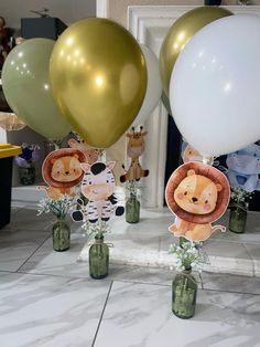 there are many balloons that have animals on them and some flowers in the vases