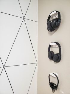 two headphones are hanging on the wall next to each other with earbuds