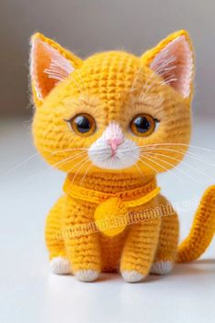 a crocheted yellow cat sitting on top of a table