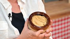 a woman holding a jar filled with some kind of food