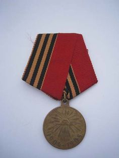 an old medal is displayed on a white surface with a black and red stripe around it