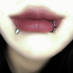 a woman's lips and nose piercings are seen in this image from the bottom