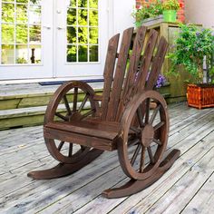 a wooden rocking chair sitting on top of a wooden deck next to potted plants