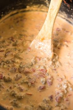 a wooden spoon stirring some food in a pot