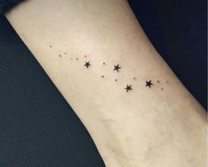 a small star tattoo on the left side of the arm, with stars all over it