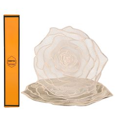 an orange box with a white rose on it next to a cardboard package for the packaging