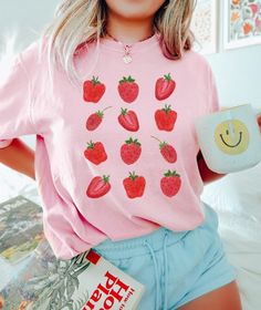 This comfort colors strawberry shirt is the perfect fruit shirt for this season! It's great for the strawberry lover, nature lover, plant-based, vegan, and cottagcore aesthetics. The soft-washed, garment-dyed fabric brings extra coziness to your wardrobe, while the relaxed fit makes it an excellent daily choice! 🤩 Tip: THESE RUN TRUE TO SIZE. If you want an oversized look, size up 2-3 sizes. 😉 ✅ Shirt Information: Comfort Colors Unisex Shirt - 100% ring-spun cotton - Medium fabric  - Relaxed f Cute Strawberry Print Tops For Spring, Sweet Short Sleeve Tops With Fruit Print, Sweet Fruit Print Summer Tops, Sweet Summer Tops With Fruit Print, Sweet Fruit Print Tops For Summer, Pink Fruit Print Tops For Summer, Red Strawberry Print Top For Summer, Sweet Red Summer Tops, Cute Strawberry Print Shirt For Spring