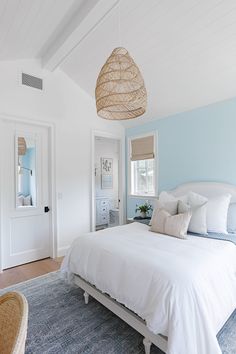 a bedroom with blue walls and white bedding