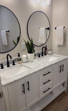 a bathroom with double sinks and mirrors in the wall above them is shown, along with two round mirrors on either side of the sink