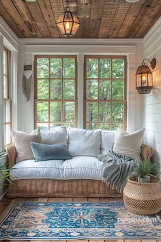 a living room filled with lots of furniture and pillows on top of a wooden floor