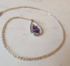 This listing is for a real bluebell stem handpicked and pressed from my garden containing 2 flower heads.  This is set in resin inside a tear drop shaped silver effect bezel pendant on a 24" silver effect chain.This necklace is so beautiful and one of a kind. It would make the perfect gift for someone special.  Please note there are many tiny bubbles in the resin as you can see in the photos.Please visit my shop to see all the other types of pressed flower necklaces for sale. Delicate Jewelry With Natural Inclusions For Gifts, Delicate Jewelry With Natural Inclusions As Gift, Handmade Teardrop Jewelry For Mother's Day, Silver Teardrop Pendant Jewelry For Mom, Dainty Teardrop Pendant Jewelry Gift, Dainty Teardrop Necklace For Gift, Handmade Teardrop Necklace Gift, Handmade Teardrop Necklace As A Gift, Dainty Teardrop Necklace As A Gift