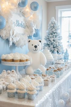 a table topped with cupcakes and cakes next to a white teddy bear