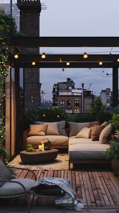 an outdoor living area with couches, tables and lights on the roof top terrace