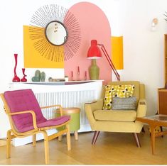 two chairs and a table in a room with yellow, pink, and green accents