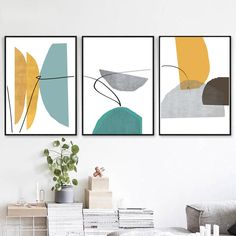 three abstract paintings hang on the wall in a living room