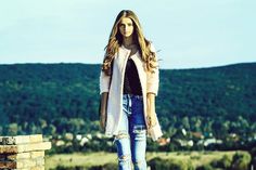 a woman standing on top of a brick wall