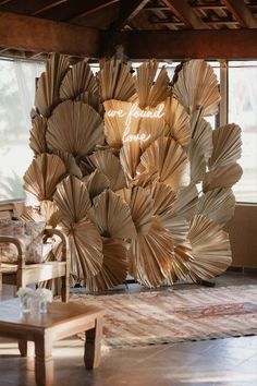 a large sculpture made out of books in a living room next to a chair and table