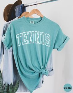 "Tennis Shirt, Tennis Player Shirt, Game Day Tennis Comfort Colors Shirt, Tennis Coach Shirt, Tennis Lover Shirt, Tennis Gift, Tennis Player Gift ✧ WHY  YOU'LL  LOVE IT ✧  ⋒ Comfort Colors® tees are garment-dyed shirts that are timeless classics and will never pile.  ⋒ Trendy retro vintage look and gorgeous colors.  ⋒ Amazingly soft and comfy. Perfect with any shorts, skirts, jeans, leggings, or nothing but undies around the house. ⋒ Created with quality in mind, it's made from 100% ring-spun co Green Top With Lettering In Relaxed Fit, Green Cotton Tops For School Spirit, Green Top With Lettering And Relaxed Fit, Basic Crew Neck Tops With Lettering, Green Relaxed Fit Top With Lettering, Cotton Tops With Lettering For College, College Short Sleeve Tops With Lettering, Sporty Short Sleeve Top With Lettering, Sporty Relaxed Fit Tops With Lettering