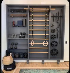 a large gray cabinet filled with lots of gym equipment and hanging hooks on it's sides