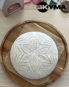 a round cake sitting on top of a wooden cutting board next to a paper towel