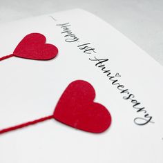 two red hearts are attached to a white card with the words happy valentine's day written on it