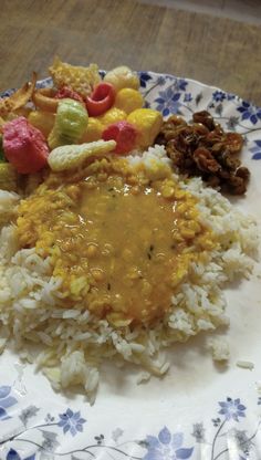 a white plate topped with rice covered in fruit and veggie toppings on top of it