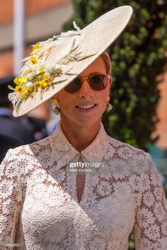 a woman in a white dress and hat with yellow flowers on it's head