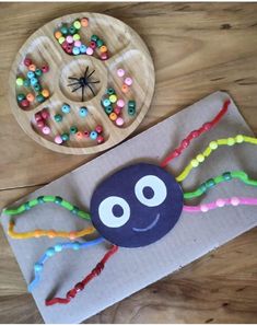 a paper plate with a spider on it next to a cardboard box filled with beads and sprinkles