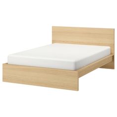 a wooden bed frame with white sheets on it